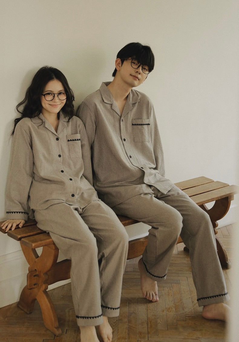 Couple seated in matching taupe striped cotton pajama sets