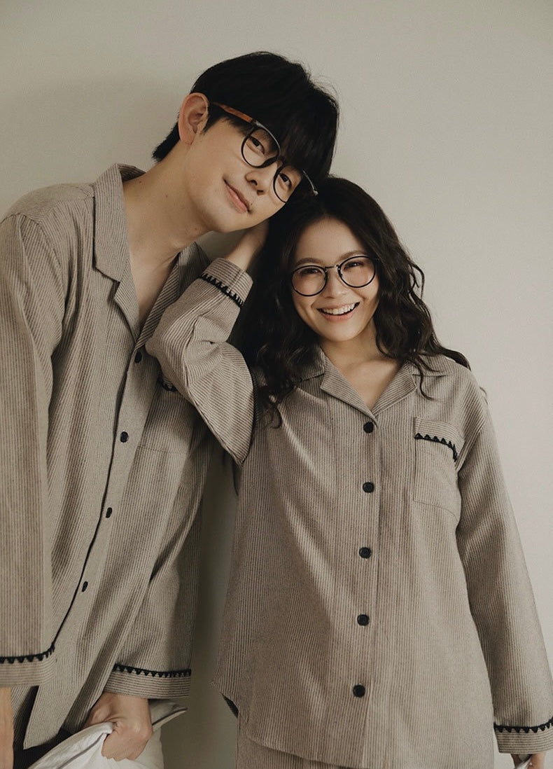 Couple wearing matching striped long-sleeve pajama tops